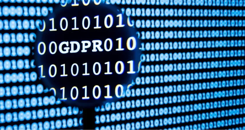 Parola GDPR mostrata in una pagina di codici binari attraverso una lente d'ingrandimento