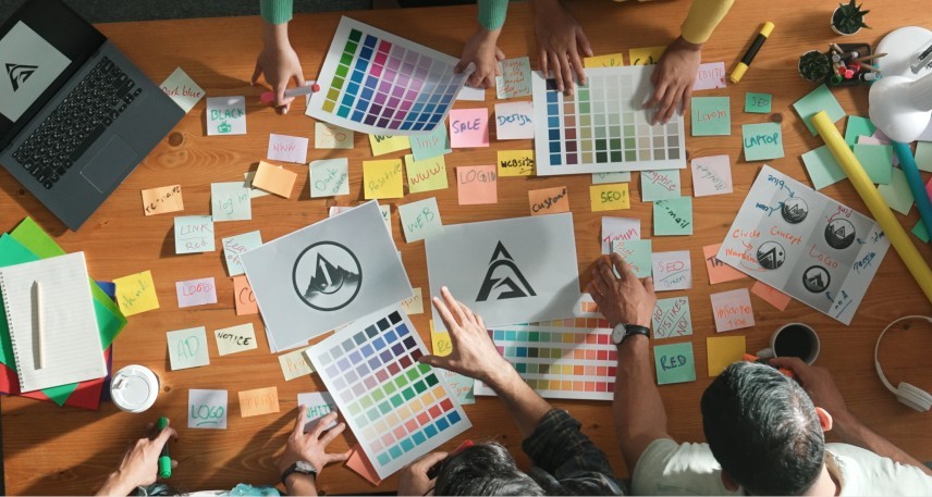 brainstorming-immagine-coordinata Colleghi che fanno brainstorming su un tavolo di lavoro per realizzare l'immagine coordinata